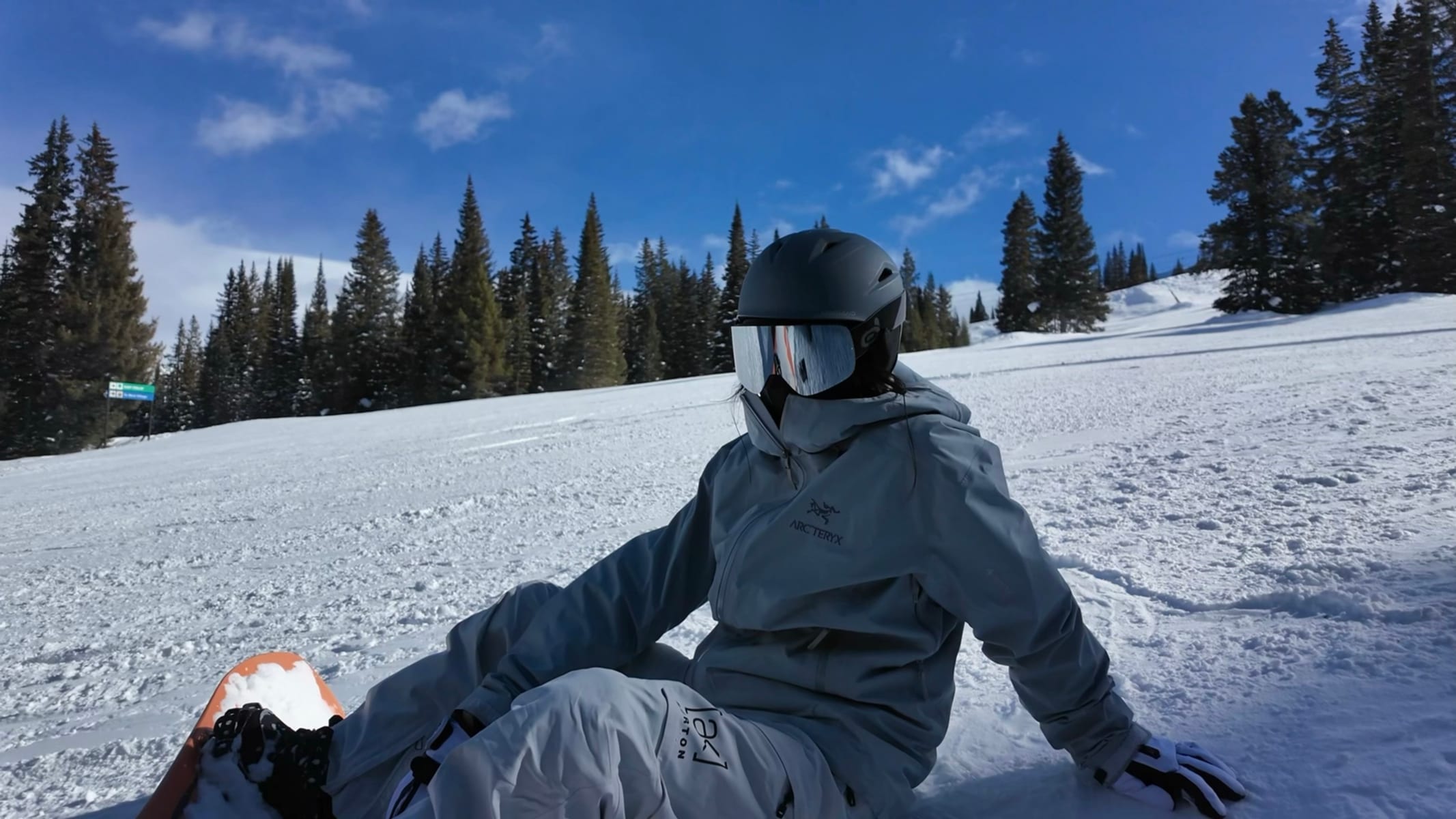 Mengqi taking a break in the snow while snowboarding