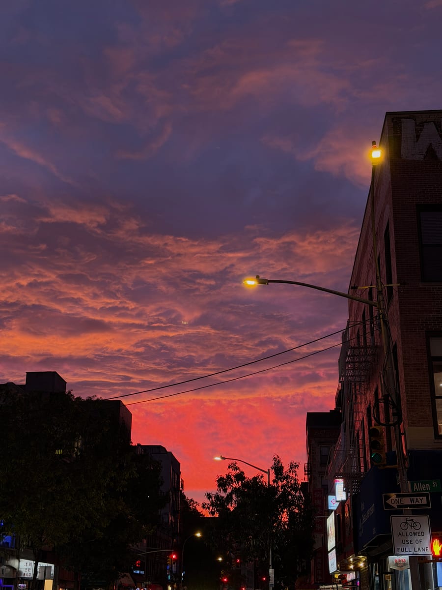 A pink and purple sunset over a city street