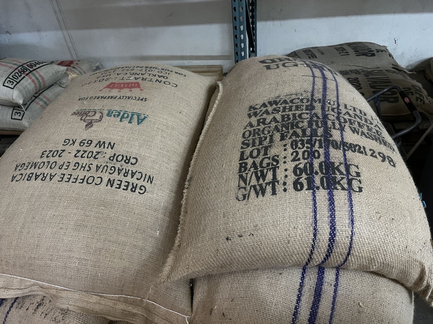 Sacks of green coffee stencilled with lot, crop year and weight.